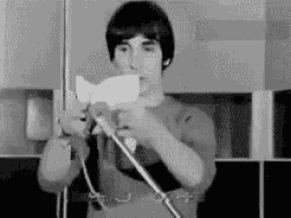a black and white photo of a young man holding a piece of paper .