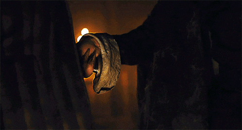 a man and a woman are standing in a room with candles