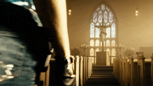 a person in a church with a statue of jesus on the cross
