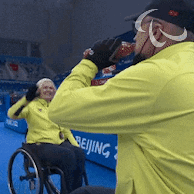 a man in a yellow jacket is drinking from a bottle
