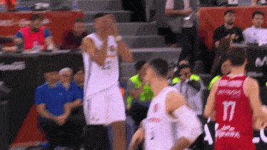 a basketball player wearing a number 17 jersey stands on the court