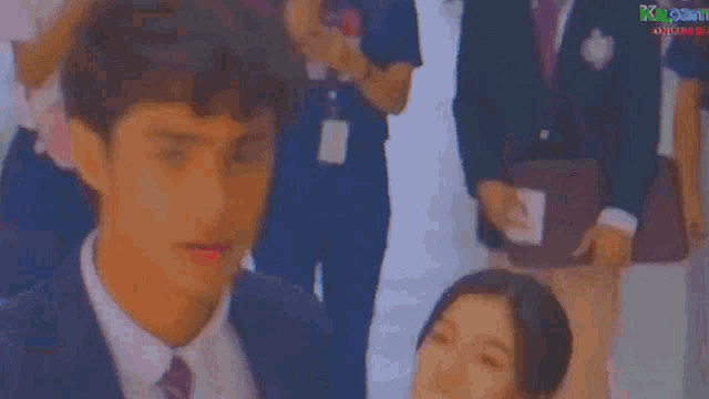 a group of people are dancing in front of a sign that says kapamilya