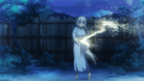 a girl in a blue dress is holding a sparkler in front of a wooden fence