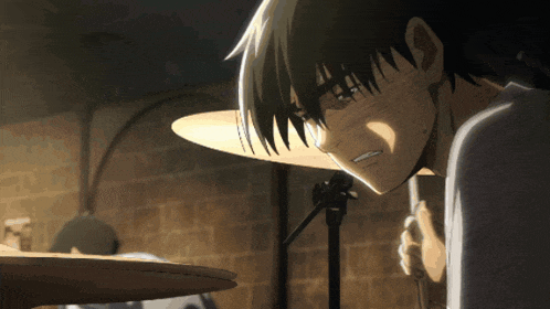 a close up of a person 's face with a drum set in the background