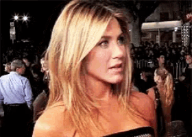 a woman in a black dress is standing in front of a crowd of people
