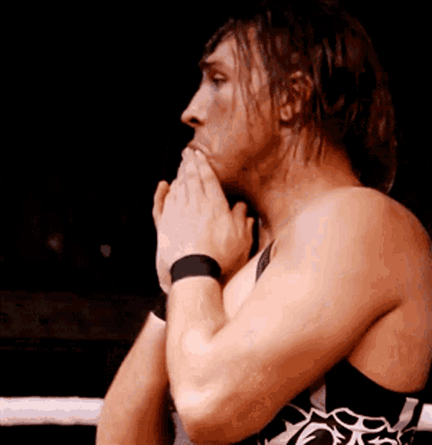 a man in a boxing ring with his hands folded in front of his face