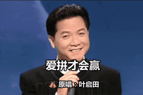 a man in a suit holds a microphone in front of a blue background with chinese characters on it