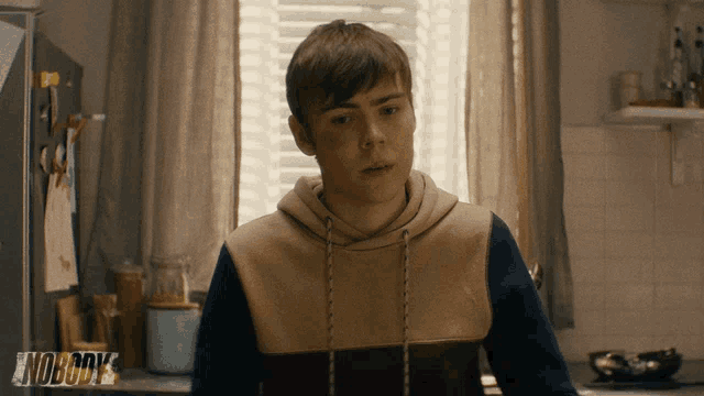 a young man in a kitchen with the word nobody on the bottom right