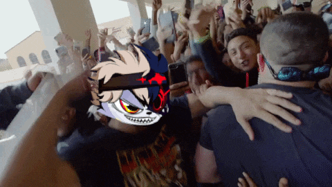 a crowd of people are gathered around a man with a cartoon character on his back .