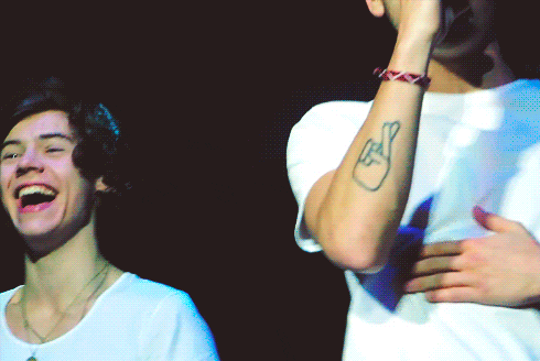 a man with a crossed fingers tattoo on his arm is smiling