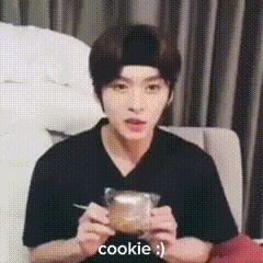 a man is sitting on a couch eating a cookie with a fork .