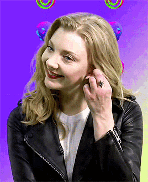 a woman wearing a black leather jacket and a ring