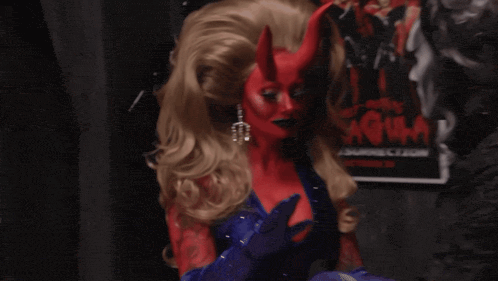 a woman with red horns is standing in front of a movie poster that says ' evil '
