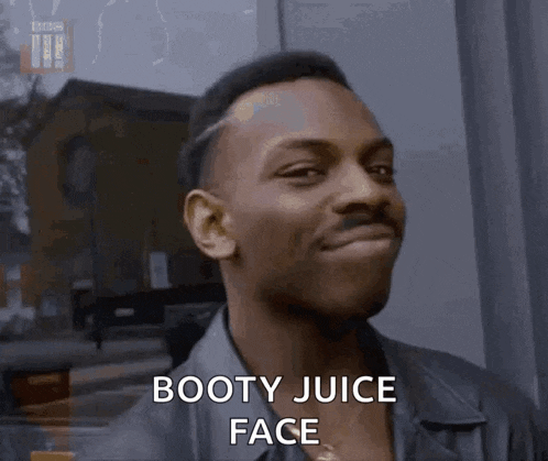 a man is smiling with the words booty juice face on his face .