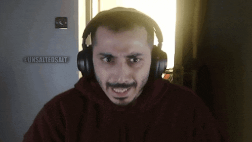 a man wearing headphones has a sign that says unsalted salt on it