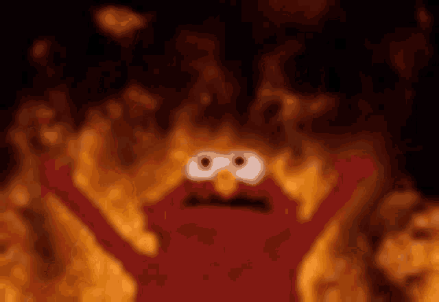 elmo from sesame street is standing in front of a fire with his arms in the air .