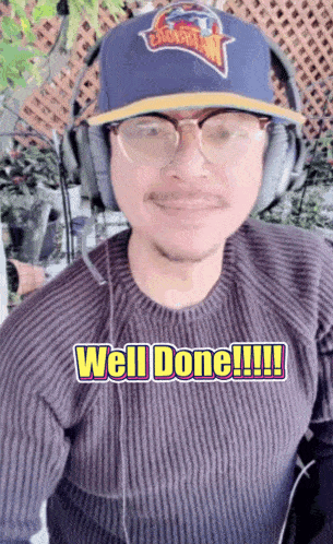 a man wearing headphones and a hat with the words well done written on it