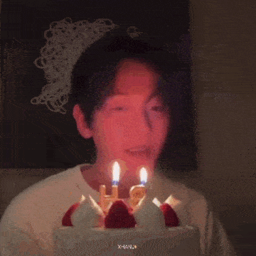 a person is blowing out candles on a birthday cake .