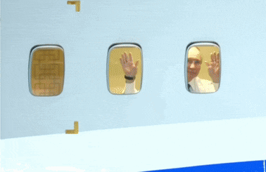 a man in a suit is looking out of a window on a plane