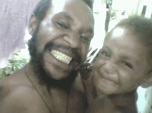 a man with a beard and a child smile for a picture