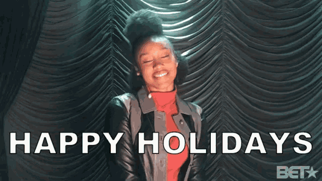 a woman is smiling in front of a curtain with the words happy holidays below her