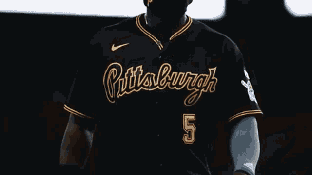 a blurry picture of two baseball players standing next to each other in a dark room .