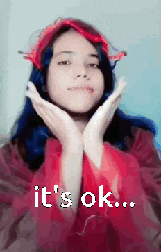 a girl with blue hair is making a funny face with the words it 's ok