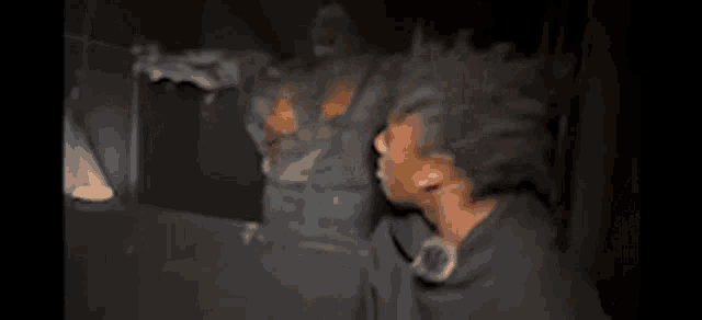 a person is standing in a dark room holding a hammer and a sword .