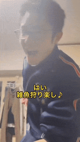 a man wearing glasses and a blue jacket with chinese writing