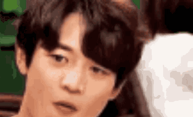 a close up of a young man 's face making a funny face .