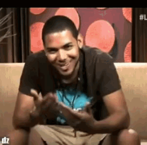 a man is smiling while sitting on a couch with dz written on the bottom right