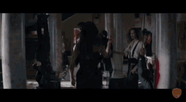 a group of people are standing in a dark room with a shield that says ' nighthawks ' on it