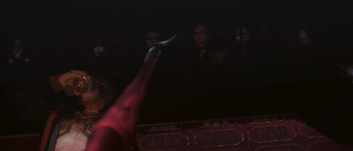 a woman with red paint on her face is surrounded by black spiders ..