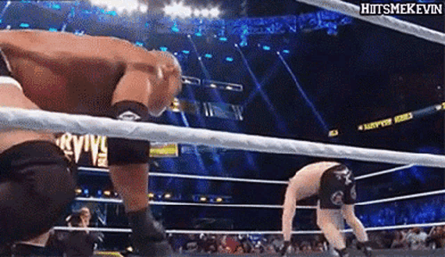 two men are wrestling in a ring with a sign that says hitsmekevin