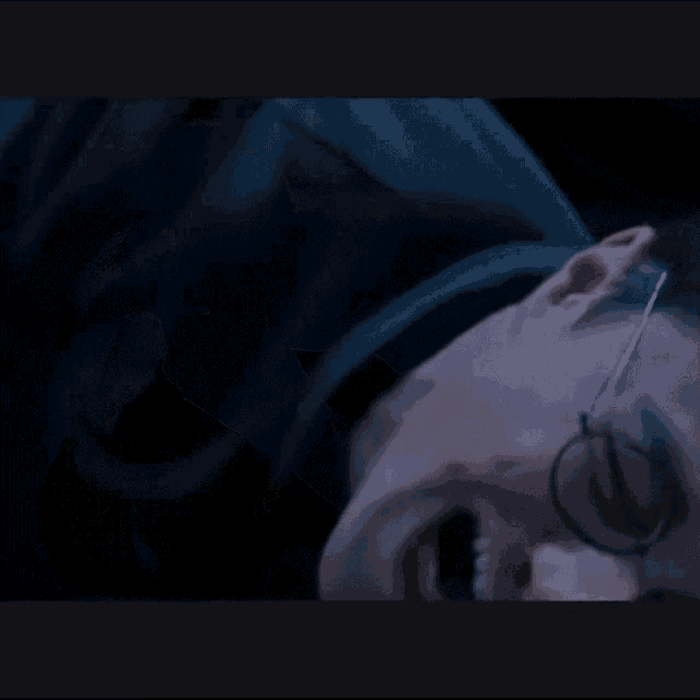 a close up of a person laying on their back with glasses on