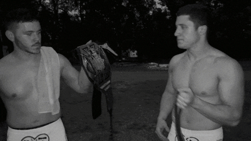 two shirtless men standing next to each other with one holding a wrestling belt that says intercontinental