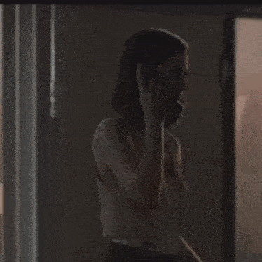a woman is talking on a telephone in a dark room