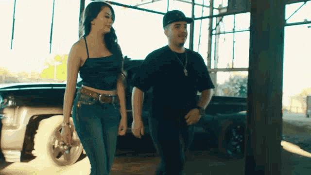 a man and a woman are standing next to each other in a garage .