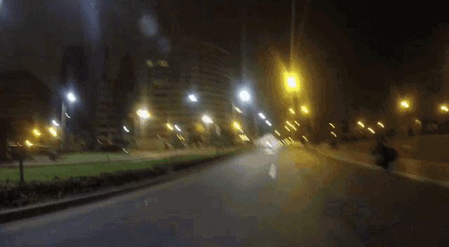 a blurry photo of a person riding a motorcycle at night