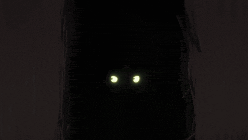 a black and white cat with its mouth open and its teeth showing