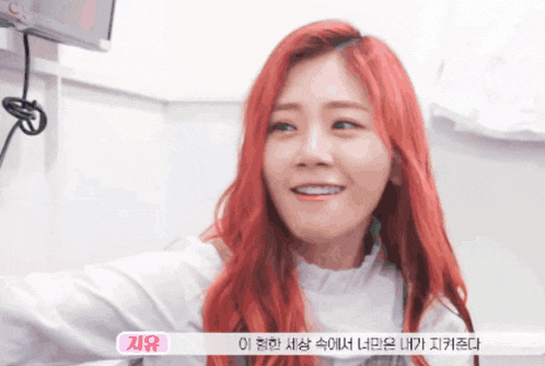 a woman with red hair is smiling with a sticker that says ' zyu ' on it