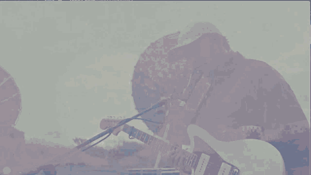 a man playing a guitar in front of a microphone with the words well i know