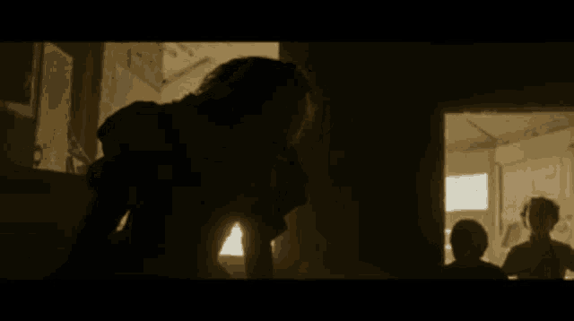 a group of people are standing in a dark room and one of them is a clown