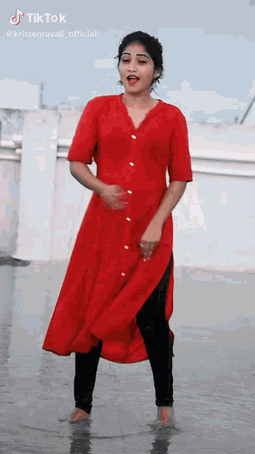 a woman in a red dress is dancing in the water with a tiktok watermark