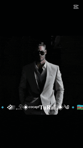 a man in a suit is standing in front of a screen that says zapcut
