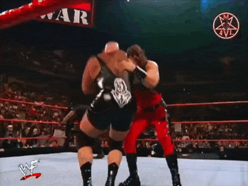 two wrestlers are in a ring with a sign that says war