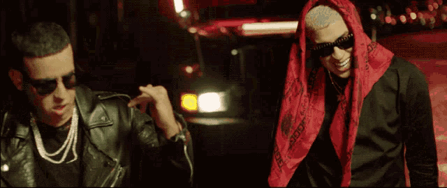 two men standing next to each other with one wearing a scarf that says gucci on it