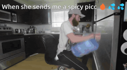 a man in a kitchen with the words " when she sends me a spicy picc " at the top