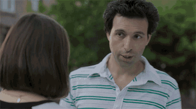 a man wearing a green and white striped shirt talks to a woman