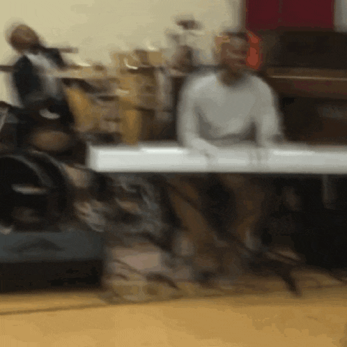 a blurry picture of a man playing a keyboard in a room